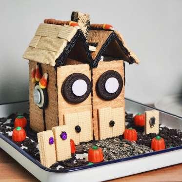 A house made of graham crackers and candy with a Halloween theme.