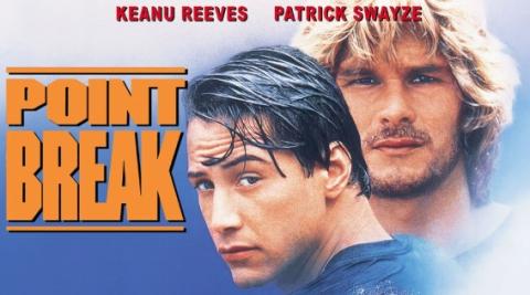 Promotional photo for the movie, Point Break. The title is in orange. Headshots of Keanu Reeves and Patrick Swayze accompany the title.